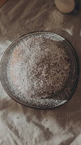 An overhead image of a round cake dusted with icing sugar
